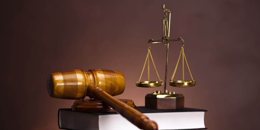 Gavel and brass scales resting on a stack of law books